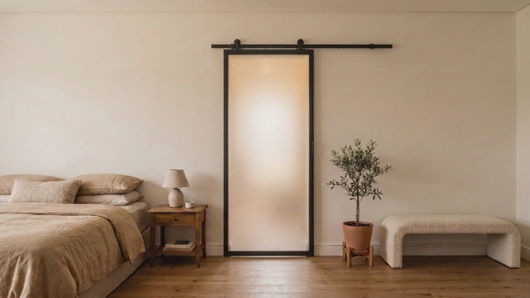 Video: single-pane frosted black steel barn door sliding open into a calm modern ensuite